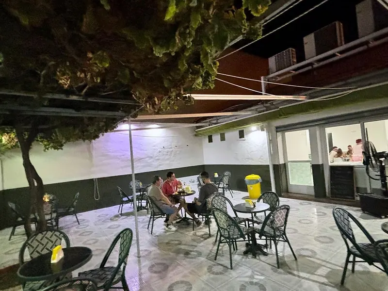 Terraza con mesas bajo la parra